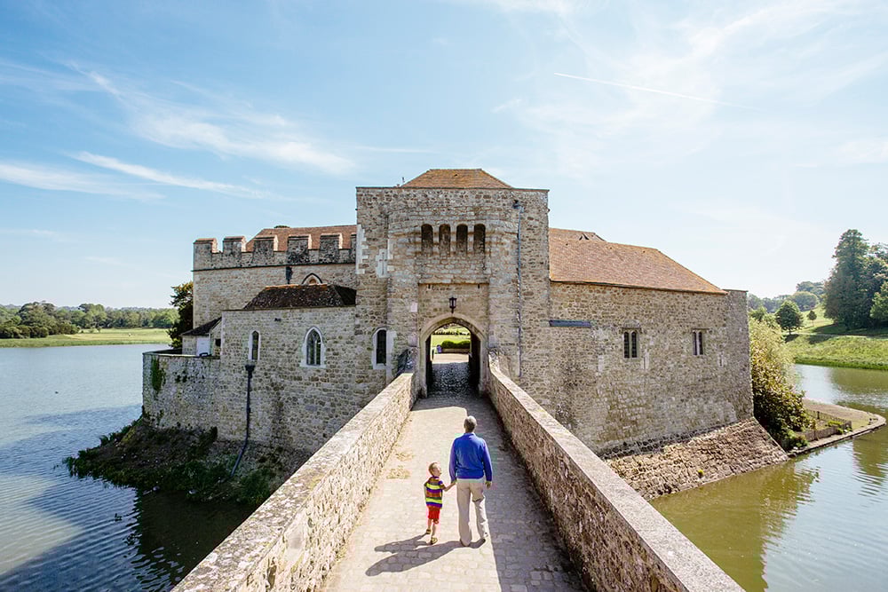 man and child on bridge walking towards castle on a sunny day - FAQs