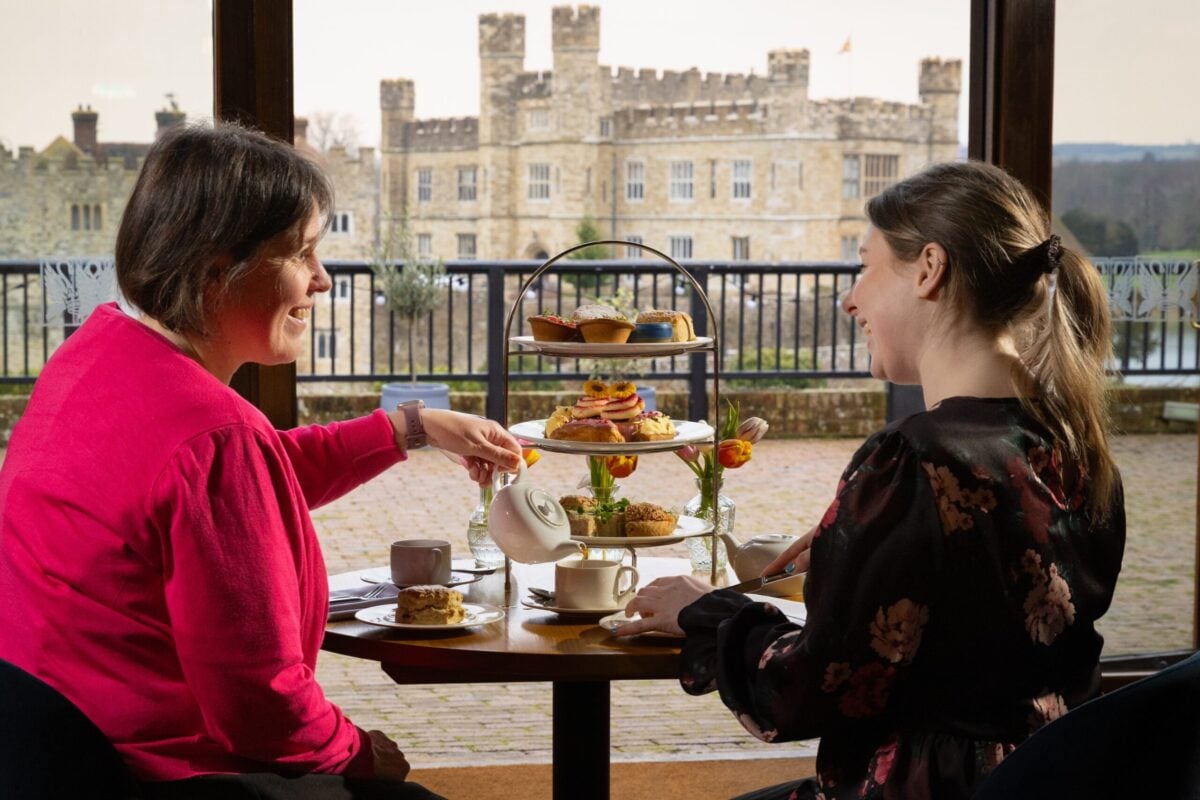 A mother and daughter eating afternoon tea across from Leeds Castle